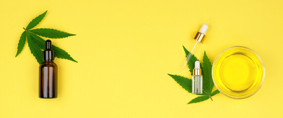 Natural hemp cosmetics concept. Composition of hemp leaves, bowls of oil and bottles of hemp oil, copy space