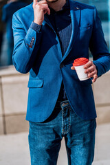 Confident businessman talking on his mobile and drinking coffee