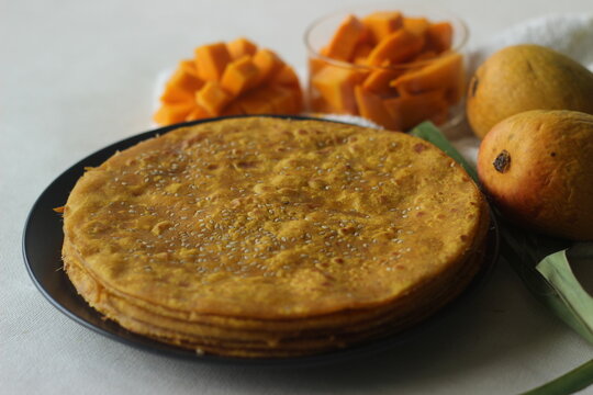 Mango Paratha. Indian flatbread made of wheat flour and mango pulp. A sweet version of Indian flatbread with fresh mangoes topped with sesame seeds.