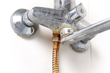The faucet, mixer and hose in the bathroom are rusty, dirty, calcined with limescale. close-up....