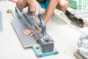 industrial tiler builder worker working with floor tile cutting equipment