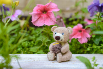 Toy handmade bear with a barrel of honey, felting wool