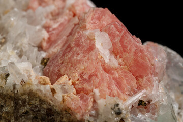 Macro of the mineral stone Rhodochrosite with fluorite on a black background