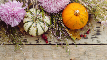 Thanksgiving rustic flat lay. Stylish pumpkins, autumn leaves, purple dahlias flowers, heather on...