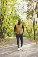 Male student walking in the park in autumn season