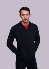 Fototapeta premium Frontal view of an attractive young brunette man in dark blue jumper and jeans. Studio photo.