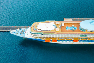 Aerial view of a luxury cruise ship or linear with a swimming pool on the roof moored in marina. 