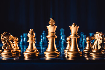 Board game chess. Figures of gold color on a blue background close-up.