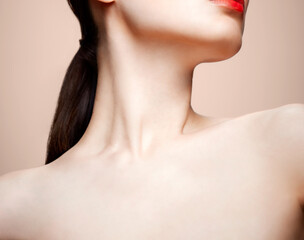 Obraz premium Women's chin, neck and collar bone on a nude background