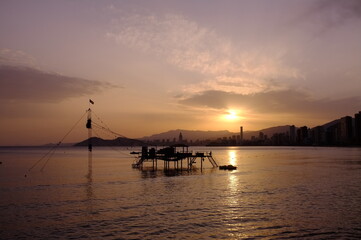 sunset over the sea with surfing tower at benidorm