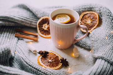 New Year's tea with a garland and oranges . Christmas mood. A cold evening. Hot drinks.