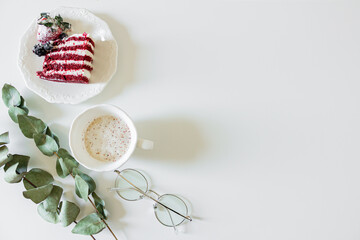 Breakfast composition with red velvet cake and a cup of milk and coffee on white background. Flat lay, top view.