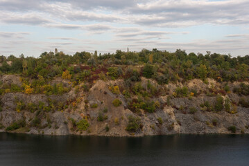 Fototapeta na wymiar autumn landscape flooded quarry against the backdrop of a cloudy sky