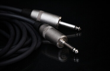 Two silver TRS connectors for the analog audio signal are placed against a black background. Professional jack connectors for sound equipment. Audiophile technologies concept.