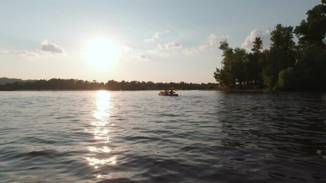 Kayaking at sunset unrecognizable people silhouette slow motion