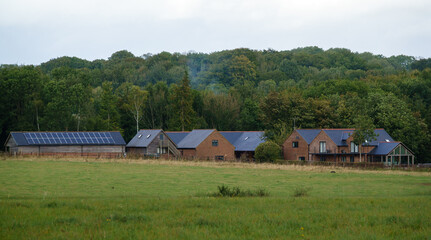 Fototapeta na wymiar a small hamlet of modern brick and wooden construction dwellings secluded on the edge of woodland and a village Wiltshire UK 