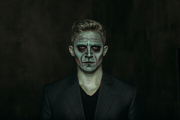 A man in the image of Frankenstein, green makeup, dark jacket, Halloween. The image of a man on...
