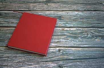 Book with red cover on wooden table against white background