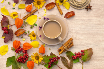 autumn composition cup of coffee on a table with flowers and leaves, top view, background picture