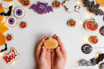 DIY Halloween gingerbread cookie. Step 1, in the hand lies shape pumpkin of ginger dough.