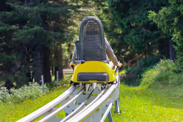 Young girl enjoying a summer fun roller alpine coaster ride