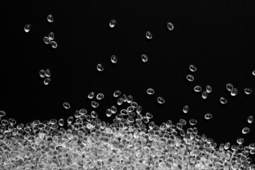 White granules of rubber, polypropylene or polyamide on a black background.