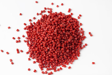 Red granules of polypropylene or polyamide on a white background. Plastics and polymers industry....