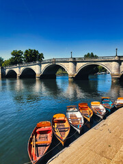 old bridge over the river with rowing boats in the foreground