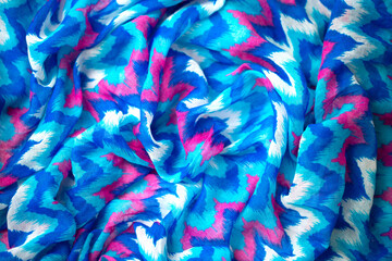 Bed linen surface at the resort. Close-up of soft multicolored wave patterns, fabric texture as...