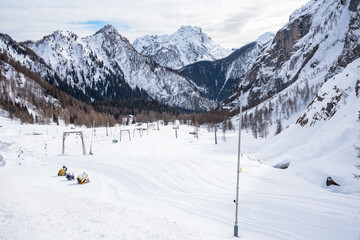 Deserted skiing slopes surrounded by majestic snowy peaks ith Alps in winter