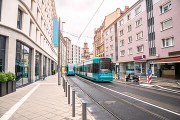 Trams running along a street lined with residential and office buildings in a city centre. Frankfurt, Germany.