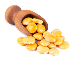 Pickled yellow lupine beans in wooden scoop, isolated on white background. Tournus, preserved lupinus.