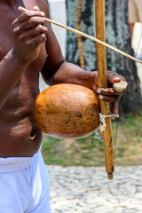 Musician playing a traditional Brazilian percussion instrument called berimbau during a capoeira...