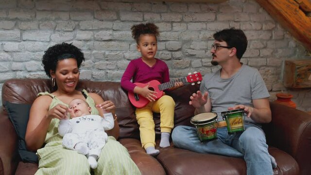 Smiling family singing together on the sofa