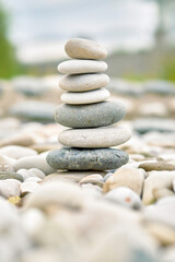 Fototapeta na wymiar Sea pebbles tower in a garden.