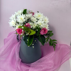  Vase of mixed colourful flower blooms.