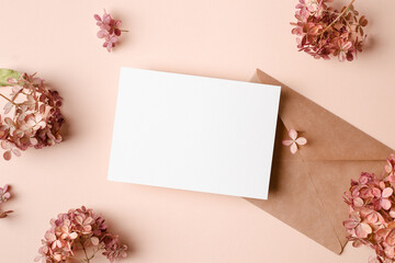 Greeting or invitation card mockup with envelope and pink hydrangea flowers decorations.