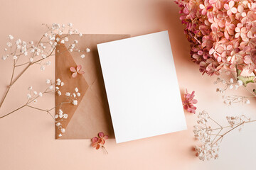 Invitation or greeting card mockup with envelope and hydrangea and gypsophila flowers decorations.
