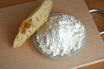 Spelt flour or pyrrhic flour and piece of bread made from it