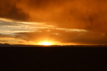 Fototapeta na wymiar storm at salt flat desert on sunset