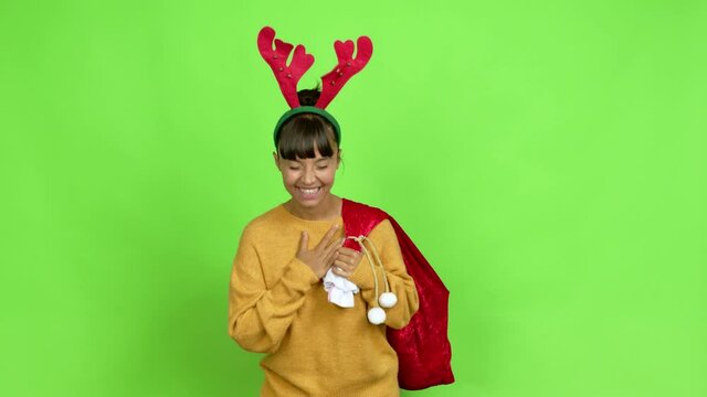 Young woman with christmas hat keeping the arms crossed while smiling over isolated background. Green screen chroma key