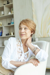 Obraz premium Cheerful mature woman smiling and looking aside