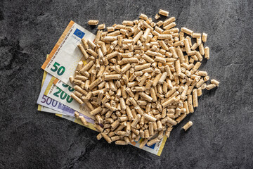 Wooden pellets and euro banknotes. Ecological heating.