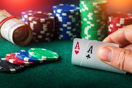 Poker cards with one pair combination. Close up of gambler hand takes playing cards in casino