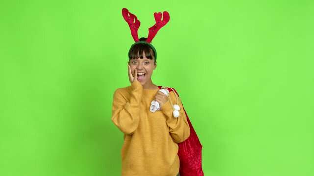 Young woman with christmas hat gaping because have just surprised with a gift over isolated background. Green screen chroma key
