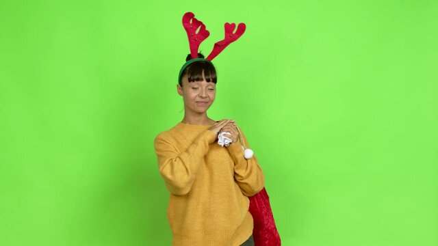 Young woman with christmas hat presenting and inviting to come with hand over isolated background. Green screen chroma key