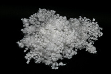 Synthetic fiber, polyester fiber, white synthetic winterizer on a black background,  siliconized holofiber. It is used as a filler for blankets, pillows, clothes and upholstered furniture.