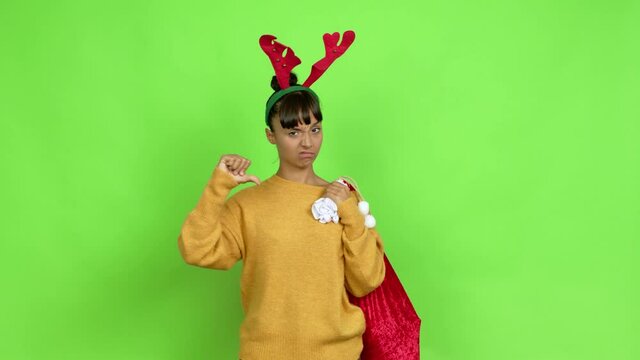 Young woman with christmas hat doing bad signal over isolated background. Green screen chroma key