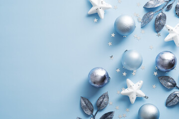 Christmas silver decorations on pastel blue background. Flat lay, top view.