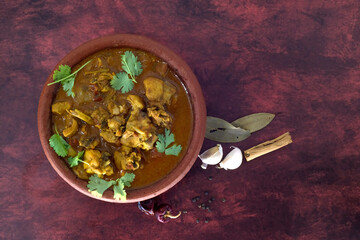 Selective focused, Chicken curry or masala or country chicken kuzhambu Tamilnadu style , chicken curry using fried coconut oil in traditional way and served in a mud pot.